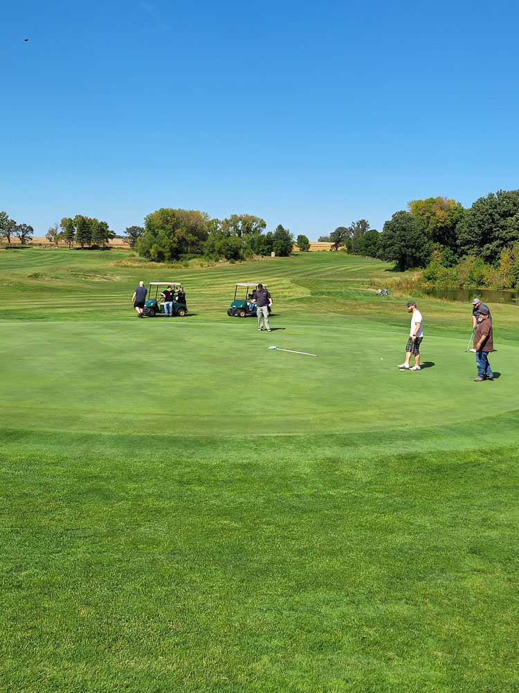 Golfers and carts on the course fairway